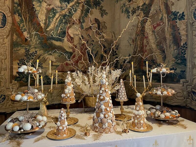 Gingerbread food concoctions on a table with a medieval tapestry as backdrop at Azay-le-Rideau castle at Christmas