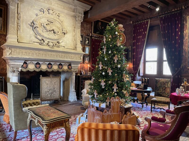 Gingerbread decorations and gifts under the tree, with the famous François I salamander fireplace in the background, at Azay-le-Rideau castle at Christmas