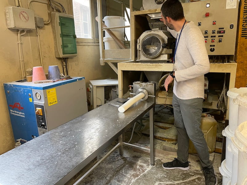 Machine pushes out cylinder of soap that will eventually become soap.